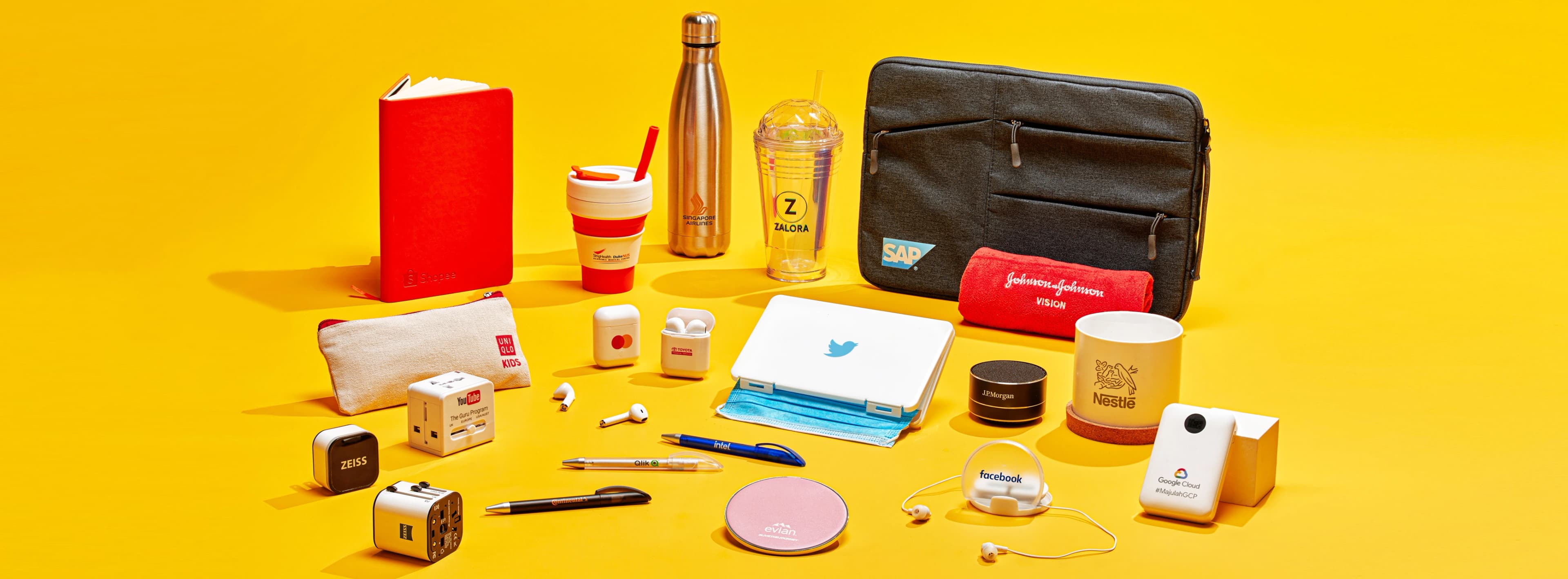 Koleksi produk hadiah korporat berlogo termasuk tumbler, notebook, power bank, dan tote bag